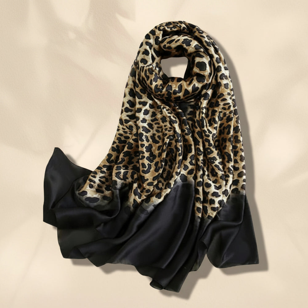 A black silk scarf with leopard print pattern, displayed on a white background.