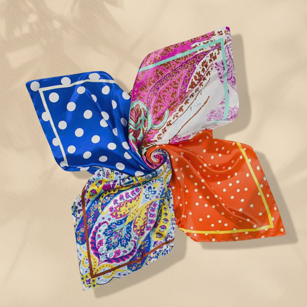 A collection of colorful silk scarves with various patterns including dots and paisley, displayed on a white surface.