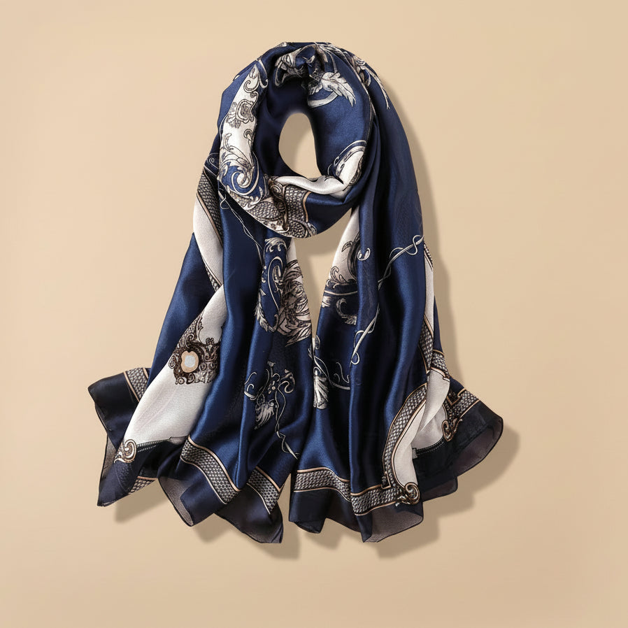 A navy silk scarf with a floral pattern displayed next to some tulips, presented as a gift.